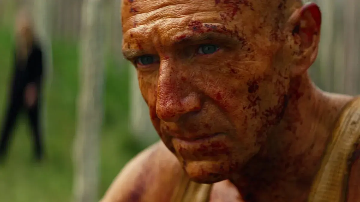 Ralph Fiennes mira hacia lo lejos en Extermino: el templo de los huesos